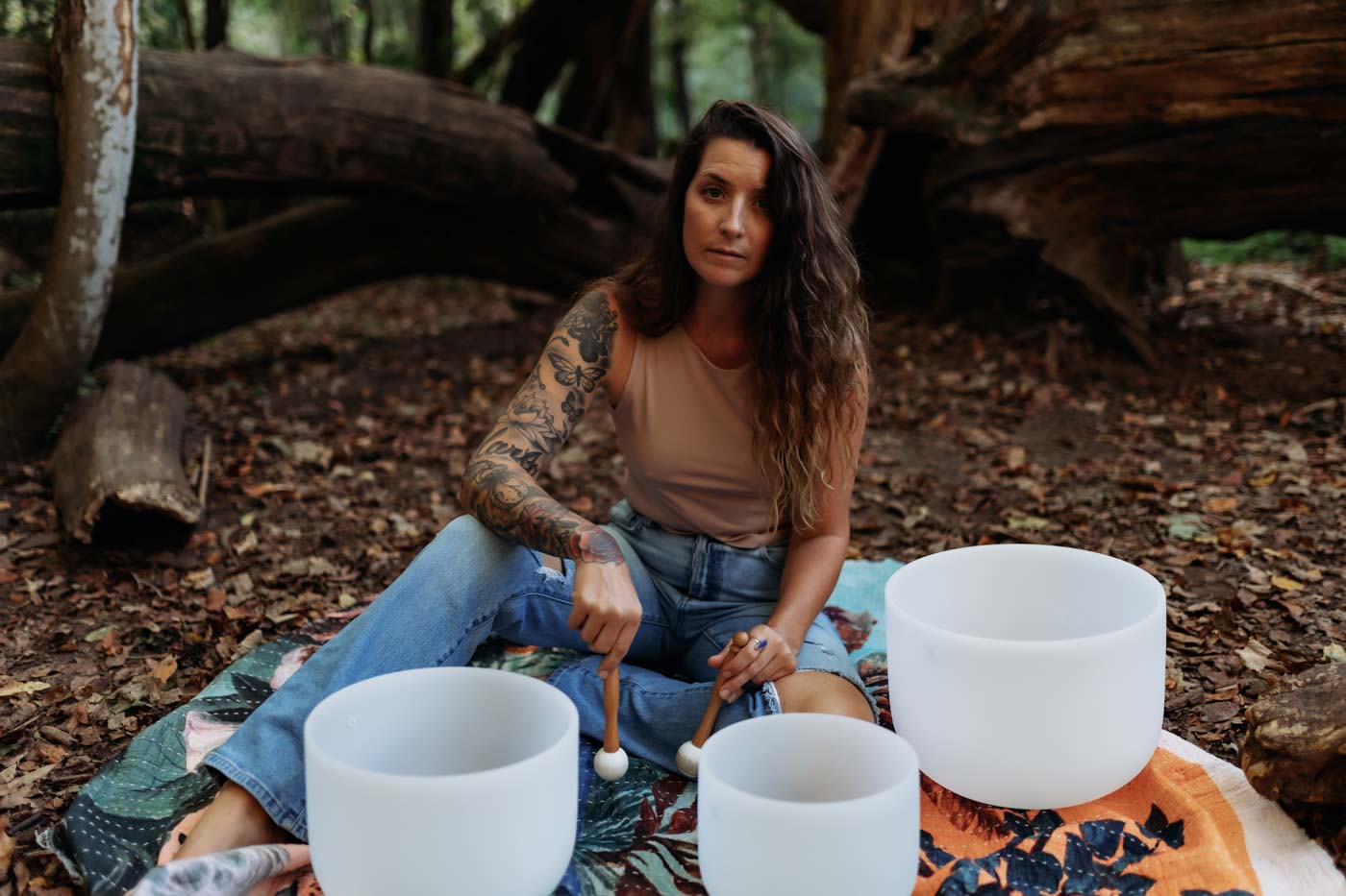 Meg Zechel sitting barefoot in the forest with singing bowls, grounded spirituality practice